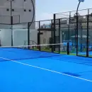 An empty glass-walled padel court