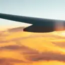 A plane wing above sunset clouds